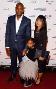 A picture of Dave Chappelle with his wife and daughter